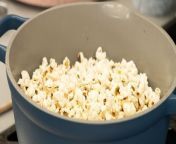 Pop your popcorn without using a microwave with this easy technique. In this video, learn how to make stovetop popcorn with butter and salt. First, pour peanut oil into the pot before adding in the popcorn kernels. Next, sprinkle enough salt to cover all of the kernels. Now, add in a few tablespoons of butter. Cover the pot and listen as your popcorn comes to life. Shake the pot back and forth until the popping stops. Finally, fill a bowl to the brim and enjoy the salty and buttery popcorn.